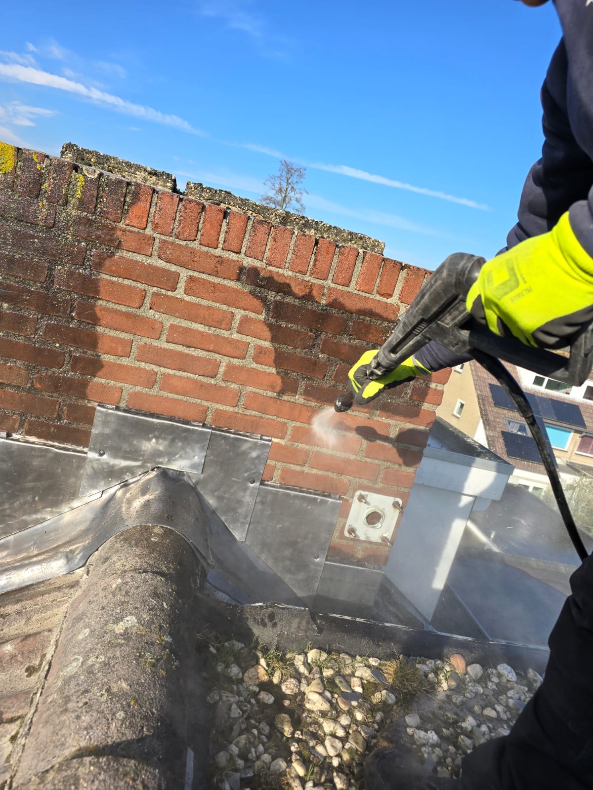 Schoorsteen wordt aangepakt, met nieuw lood en voegwerk